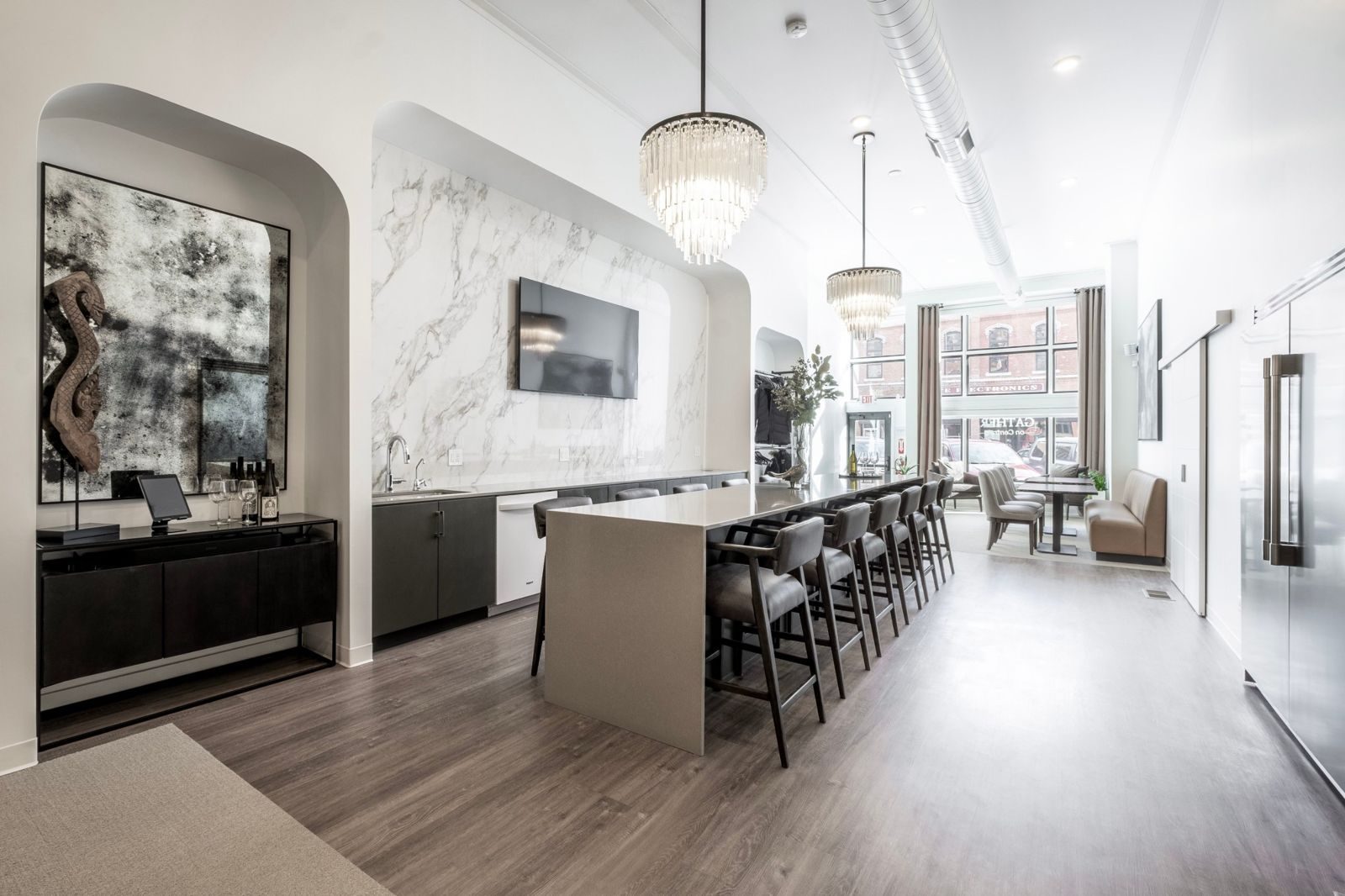 Gather on Central today: a long marble bar with stools, chandeliers, and windows onto Central Avenue