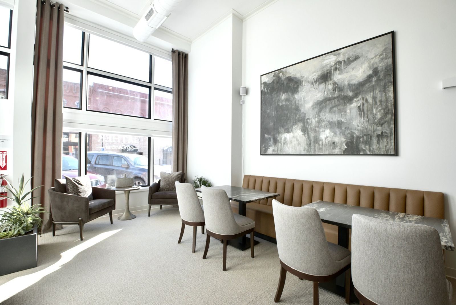 Gather on Central lounge with tall front windows, booth seating, and a large painting
