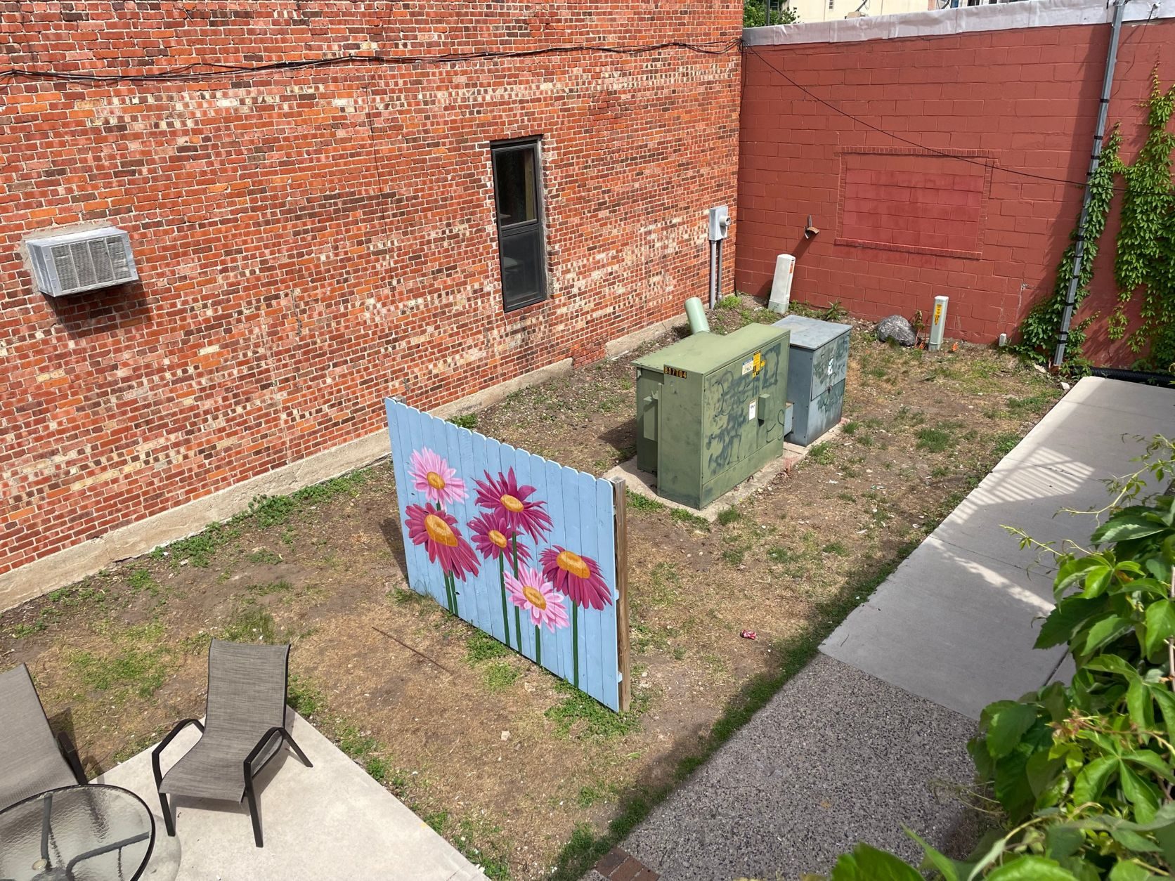 The back lot from above today, with a painted flower fence panel and bare ground